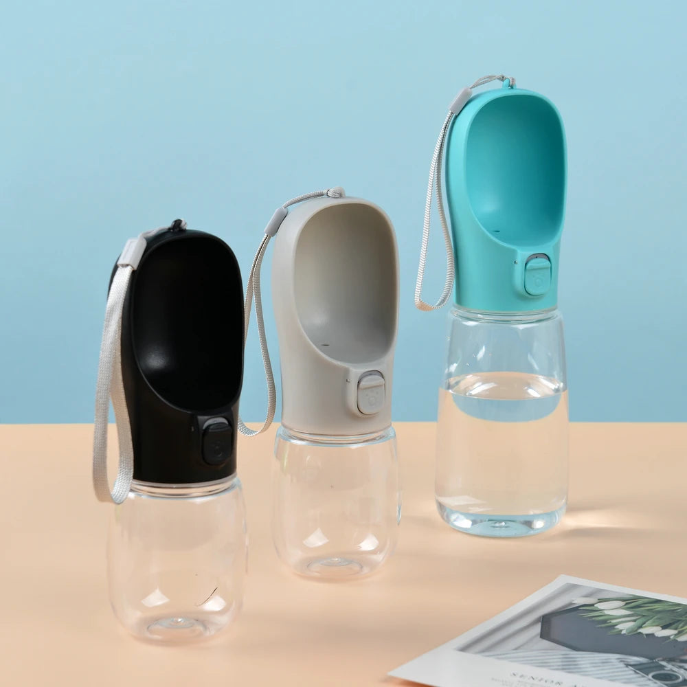 Three portable pet water bottles on a beige surface with a blue background