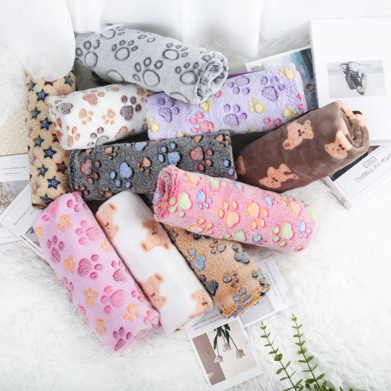 Collection of colorful pet blanketswith various patterns on a light surface.