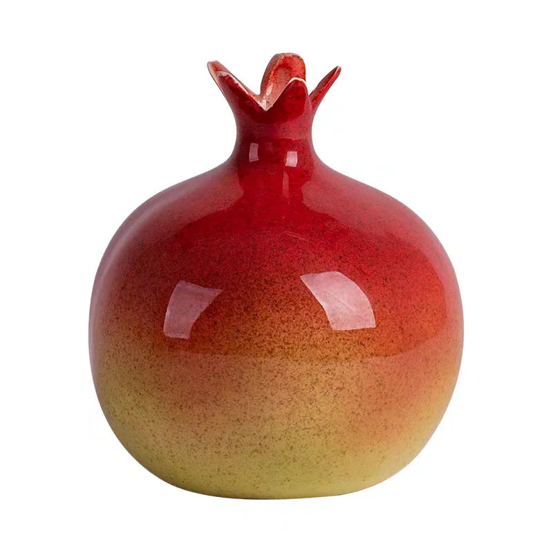 Red and yellow ceramic pomegranate-shaped vase on a white background