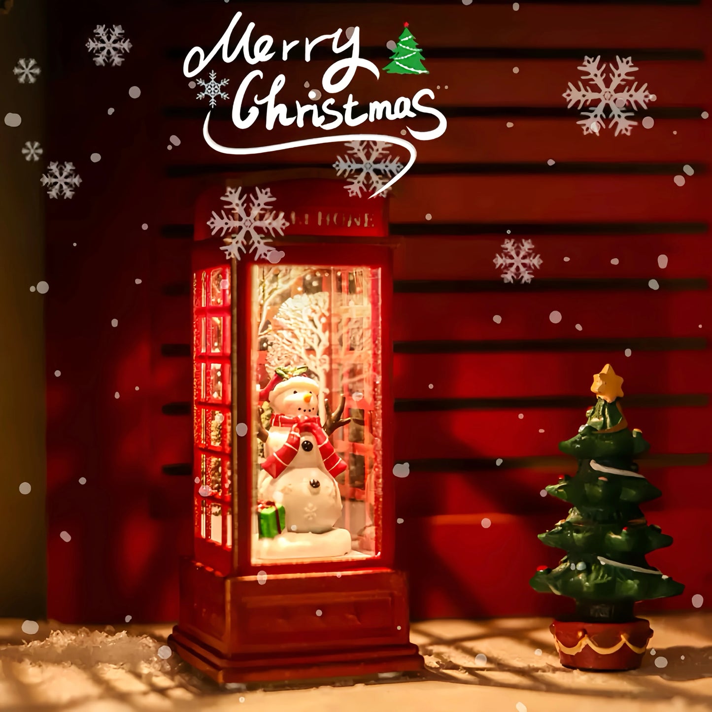 Decorative Christmas scene with a snowman in a lit-up box, small tree, and 'Merry Christmas' text.