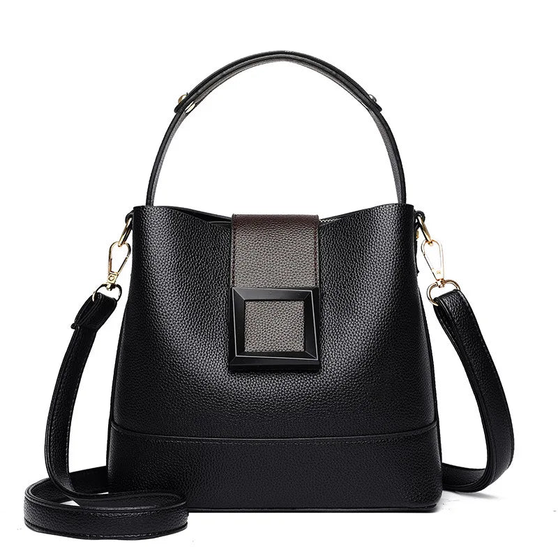 Black handbag with a decorative buckle on a white background