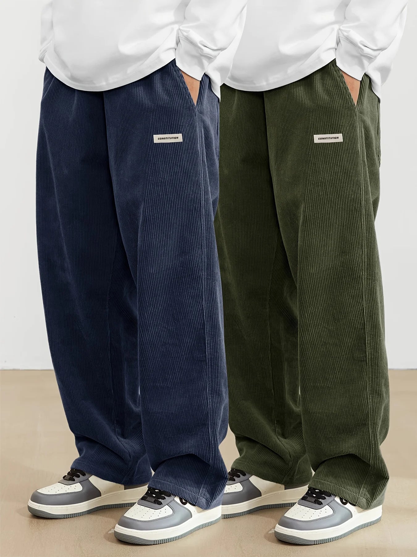Two pairs of corduroy pants, one navy and one green, worn by people against a plain background.