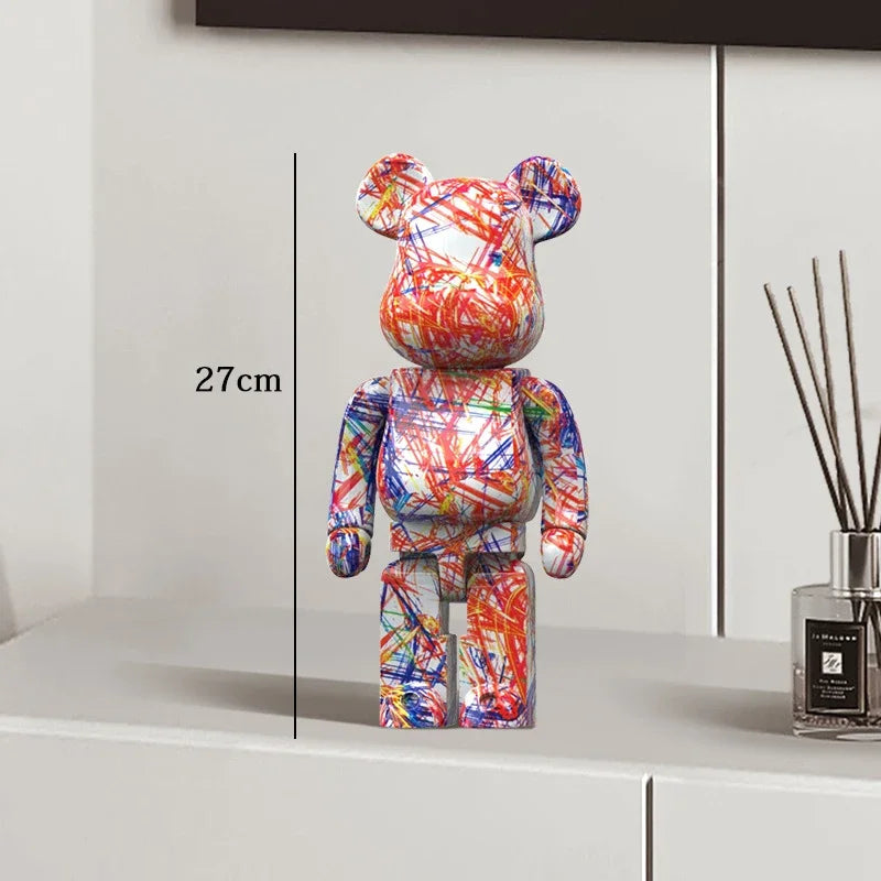Colorful bear-shaped figure on a white surface with a vase in the background