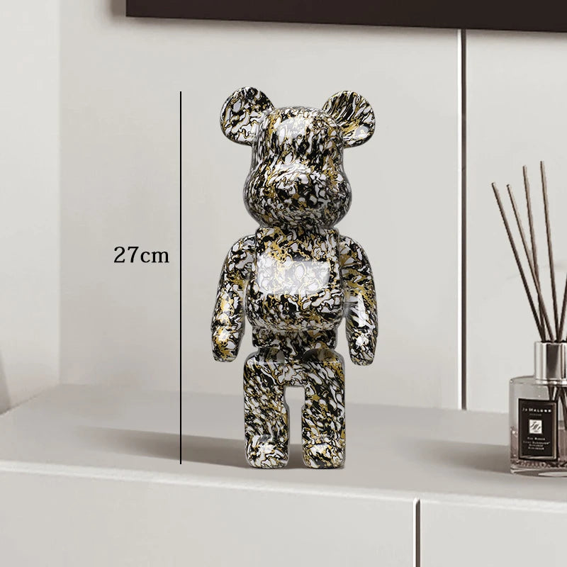 Metallic bear figure on a white surface with measurement label and diffuser in the background