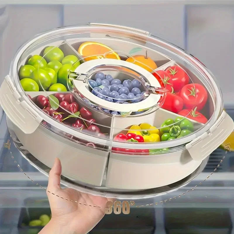 Rotating clear Snackle Box serving tray with divided compartments for fruit, nuts, sweets, vegetables and party snacks.