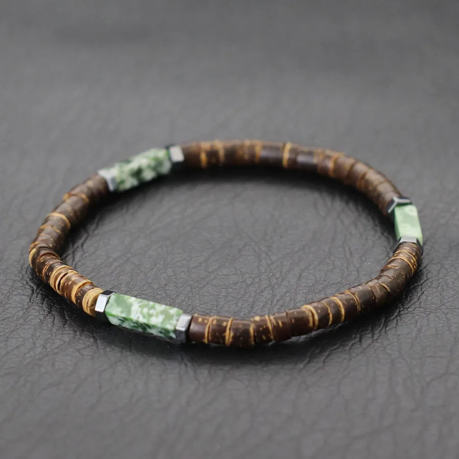 Bracelet with brown and green beads on a dark textured surface