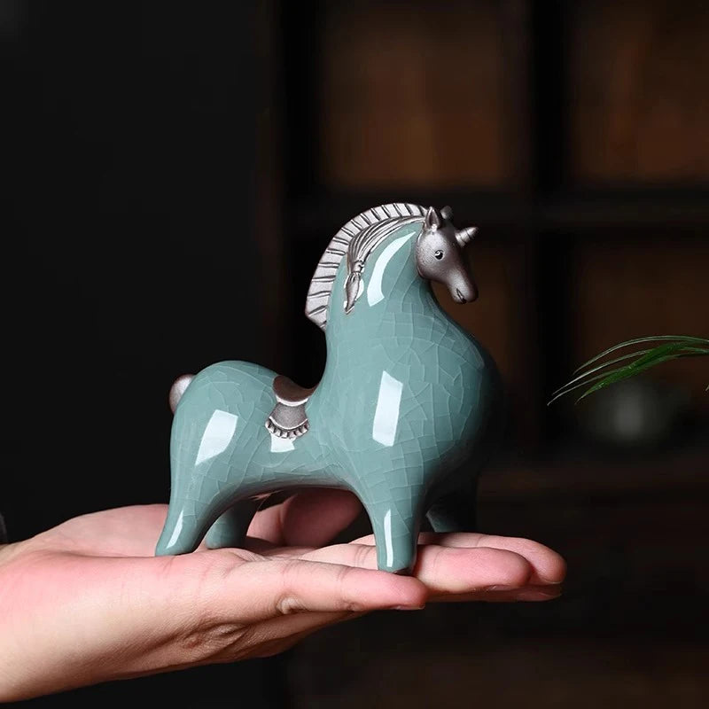 Ceramic horse figurine held in a hand with a blurred background