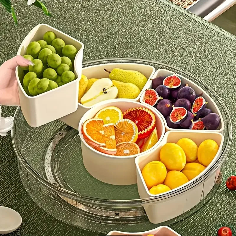 Fruit platter with compartments filled with various fruits on a green table.