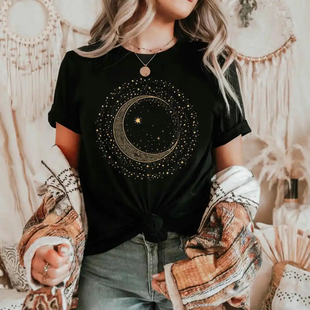 Person wearing a black t-shirt with a moon and star design in a bohemian setting.