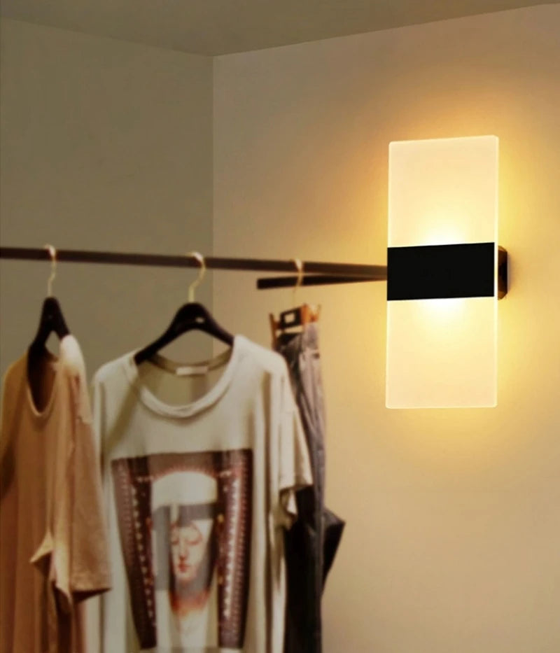Wall-mounted light fixture in a room with clothes on hangers
