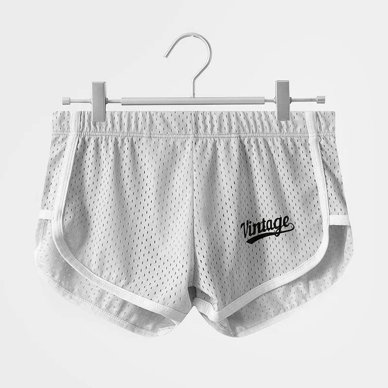 White mesh shorts with 'Vintage' logo on a hanger against a white background