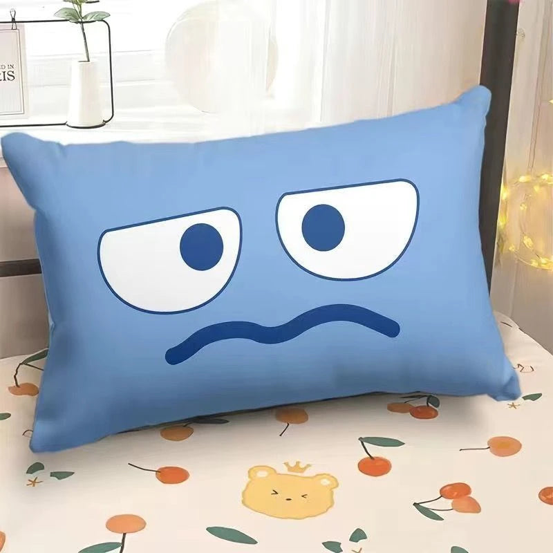 Blue pillow with cartoon face design on a bed with a floral pattern