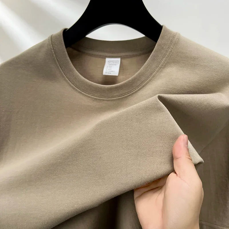 Beige sweatshirt on a hanger with a hand touching the fabric
