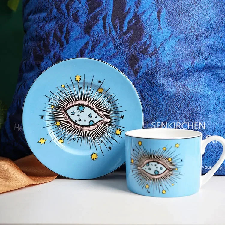 Blue ceramic plate and mug set with eye design against a blue textured background