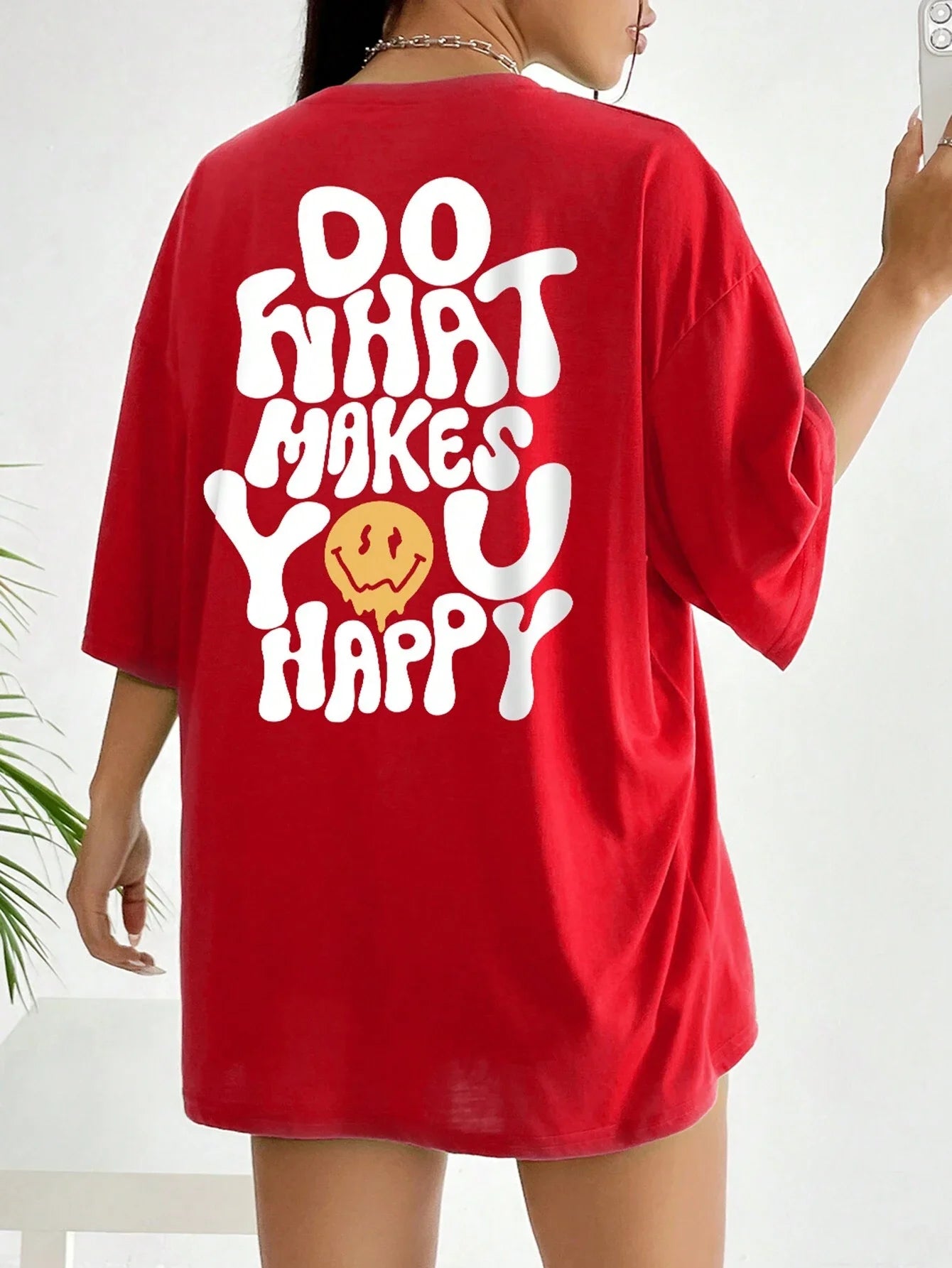 Red t-shirt with white text and smiley face on a plain background