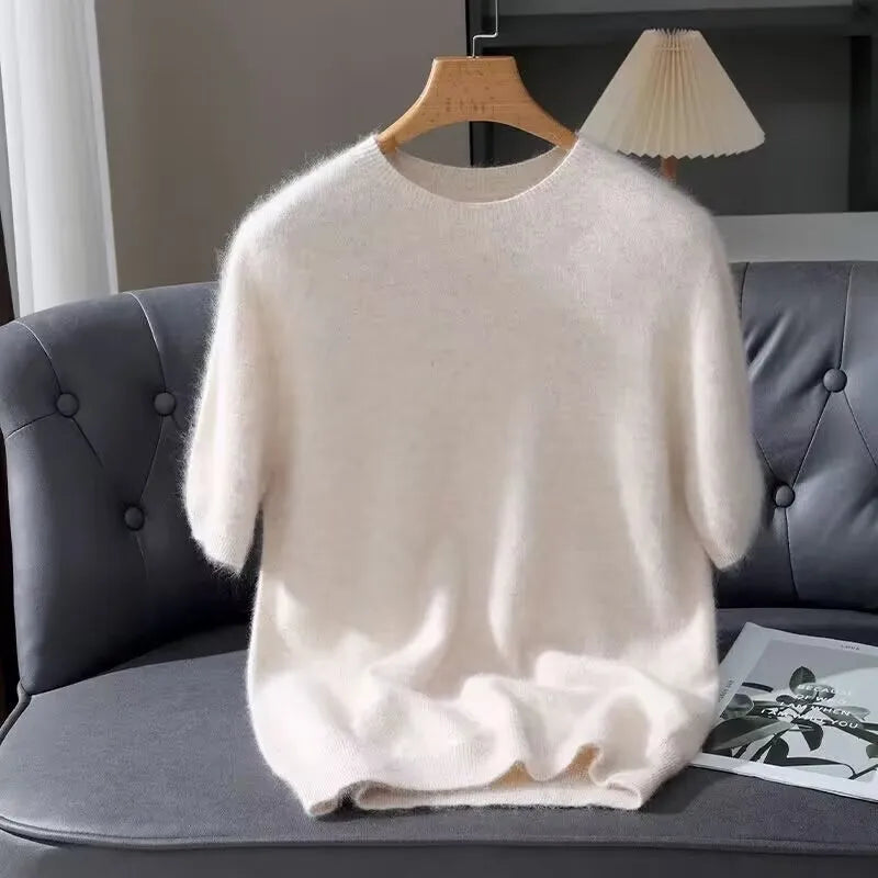 White sweater on a hanger against a gray sofa background