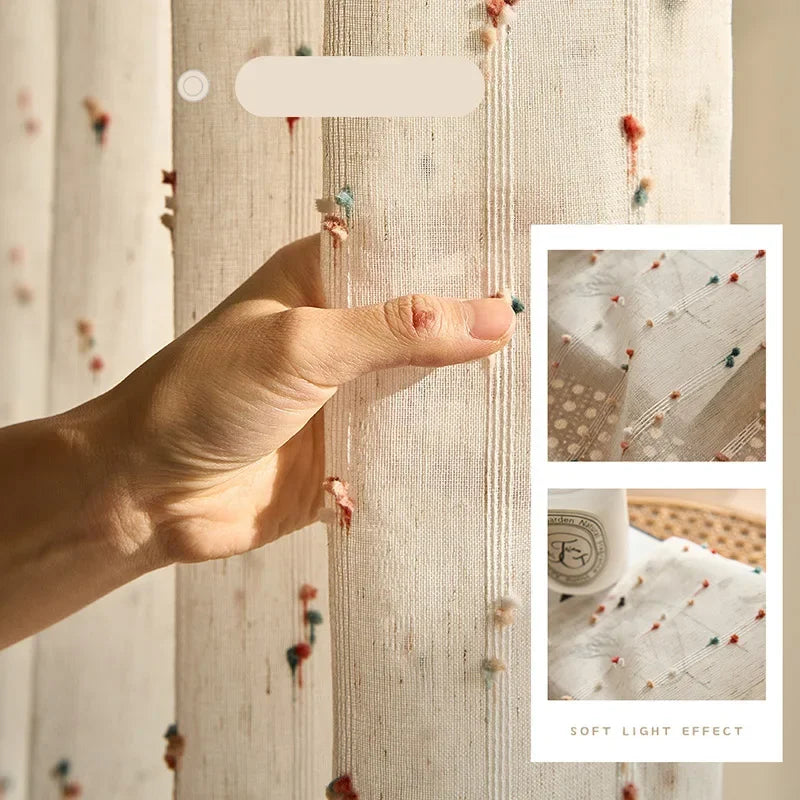 Hand holding fabric with small colorful embellishments, close-up view.