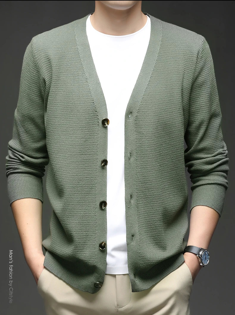 Green cardigan worn by a person on a dark background