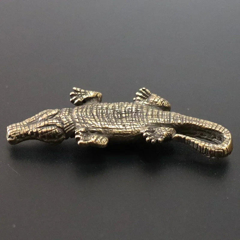 Bronze alligator figurine on a black background