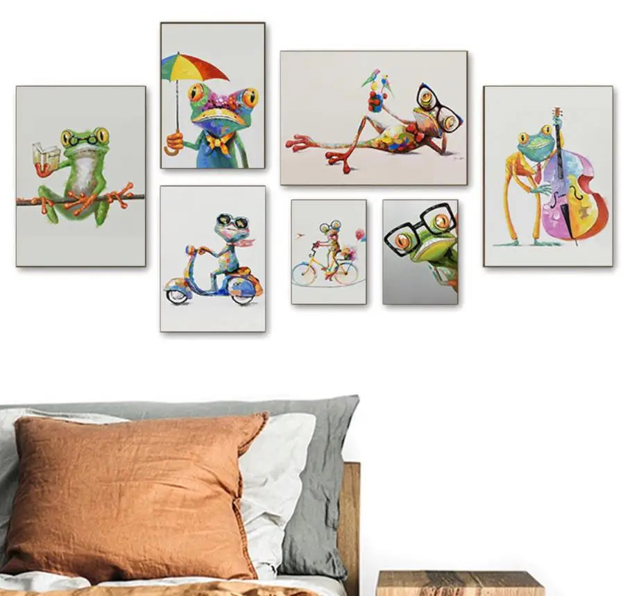 Set of colorful frog-themed wall art prints on a white wall above a bed.