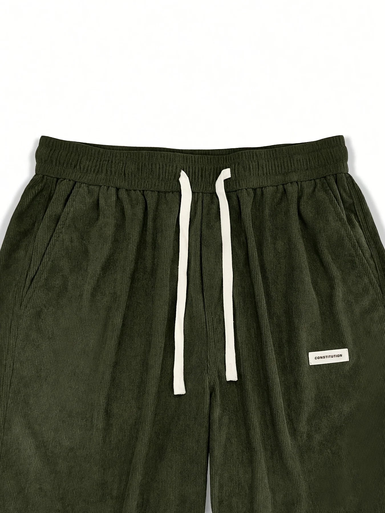 Green sweatpants with a white drawstring and brand label on a white background