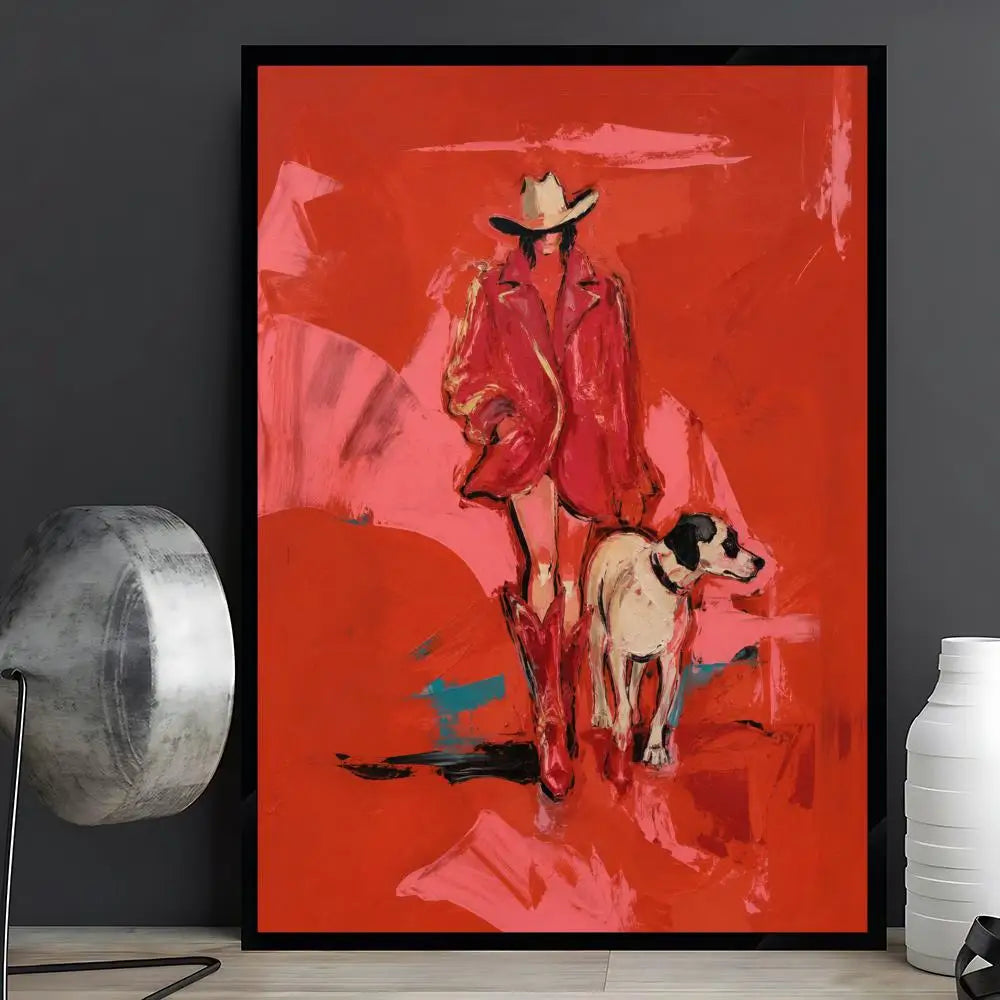 A framed abstract art print featuring a cowboy in a red coat and hat walking with a dog, displayed on a shelf against a dark gray wall with a decorative lamp and vase.