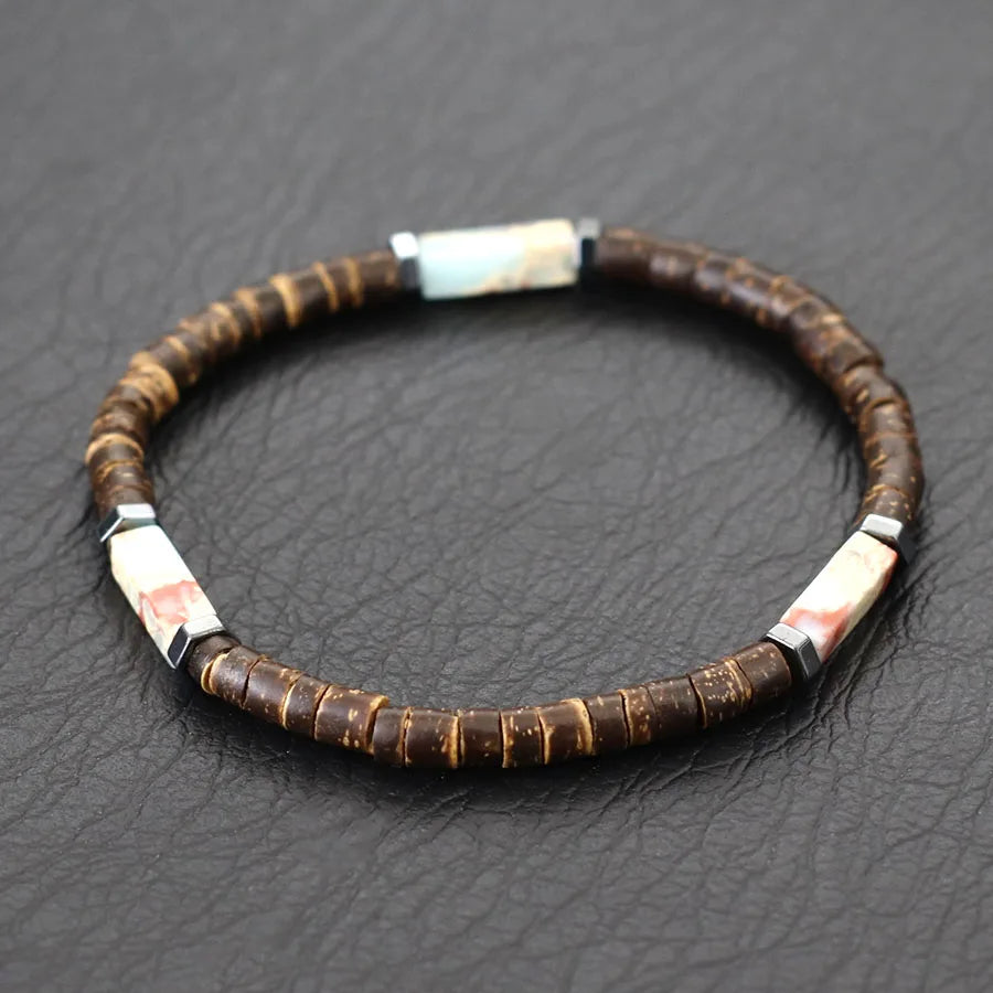 Bracelet with brown beads and white and black accents on a dark textured surface
