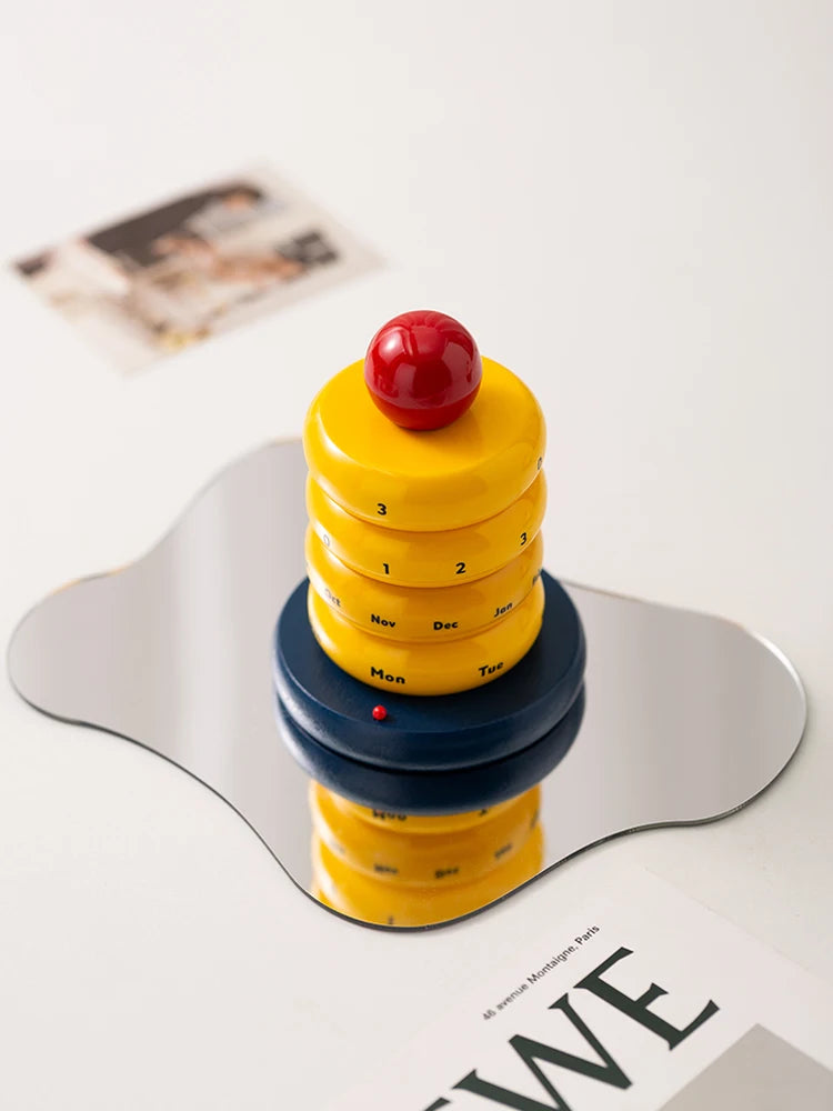 Colorful rotating cake calendar on a white surface with a blurred background