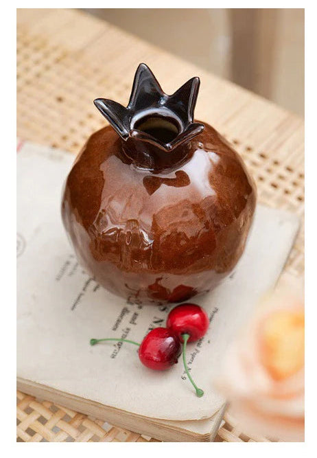 Decorative item resembling a pomegranate, placed on a textured surface.