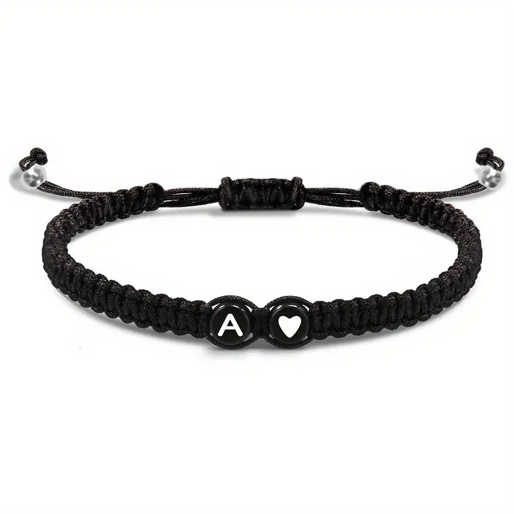 Black braided bracelet with letter 'A' and heart charm on a white background