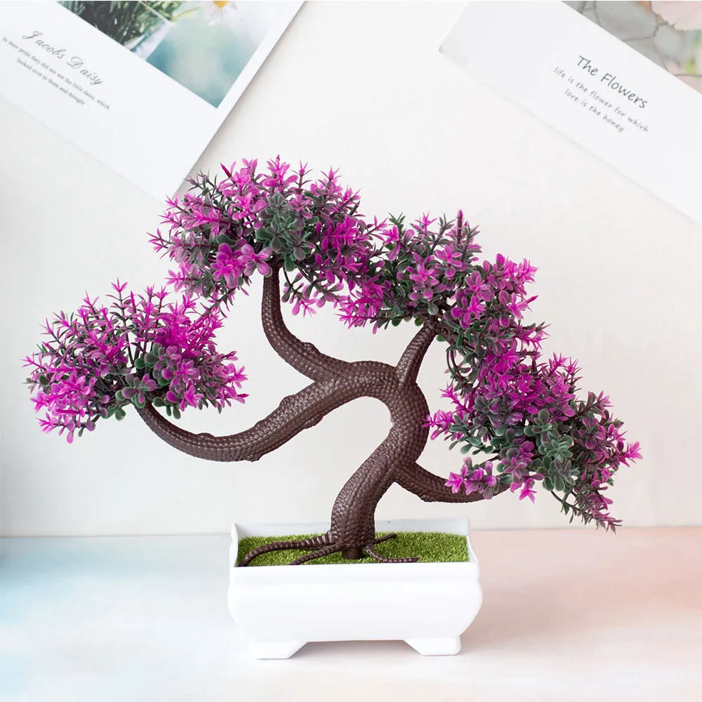 Artificial bonsai tree with pink flowers on a white surface