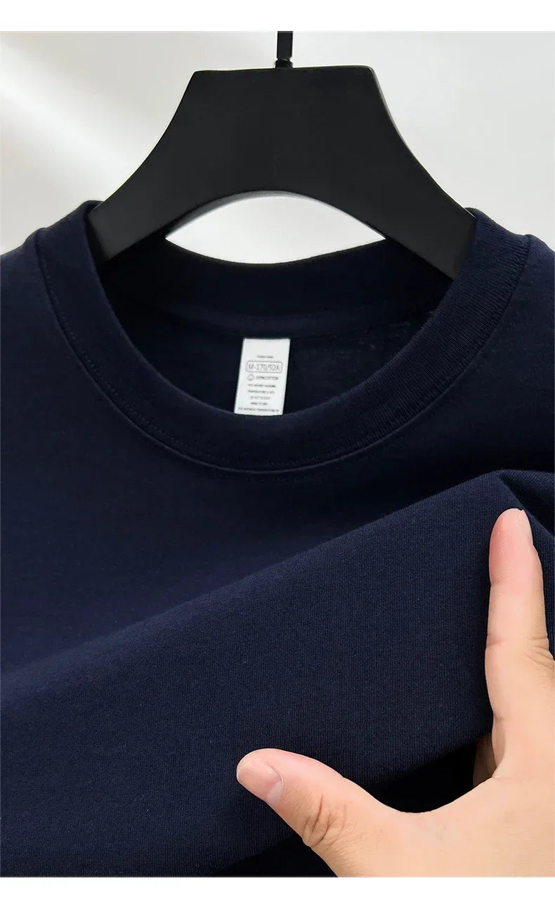 Navy blue sweatshirt on a hanger with a hand touching the fabric