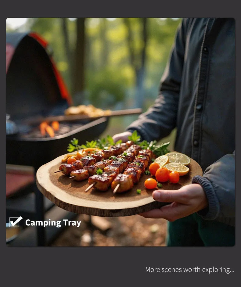 Person holding a wooden tray with skewered food and vegetables outdoors, likely camping.