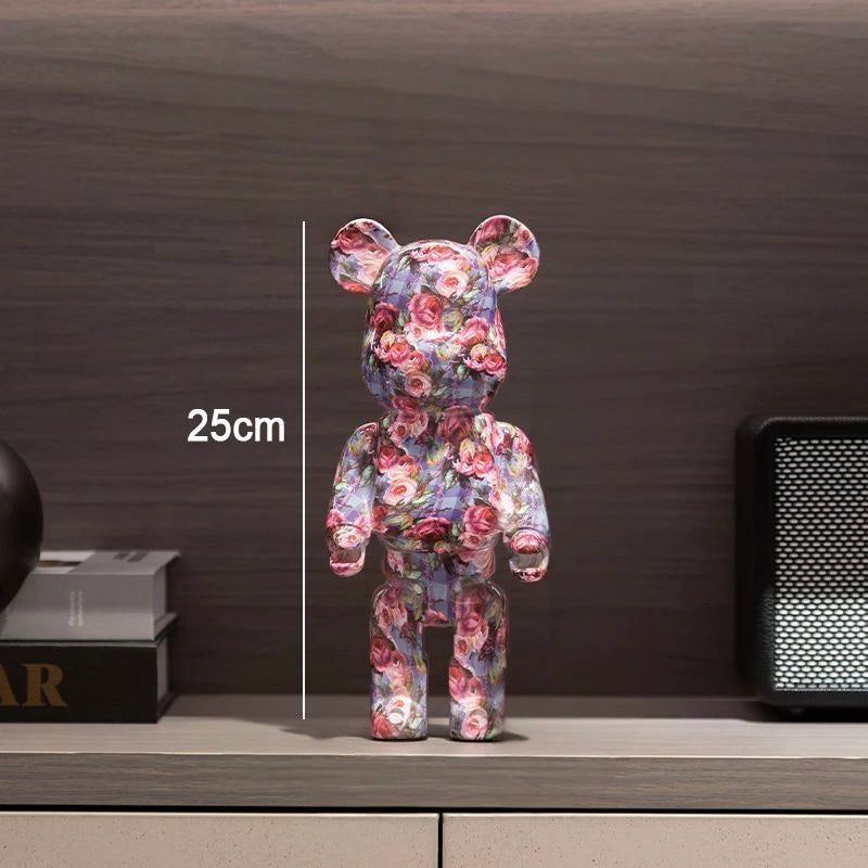 A floral bear figurine standing on a shelf, with a vertical measurement overlay reading 25cm. The background is a dark wood wall with books and a speaker partially visible.
