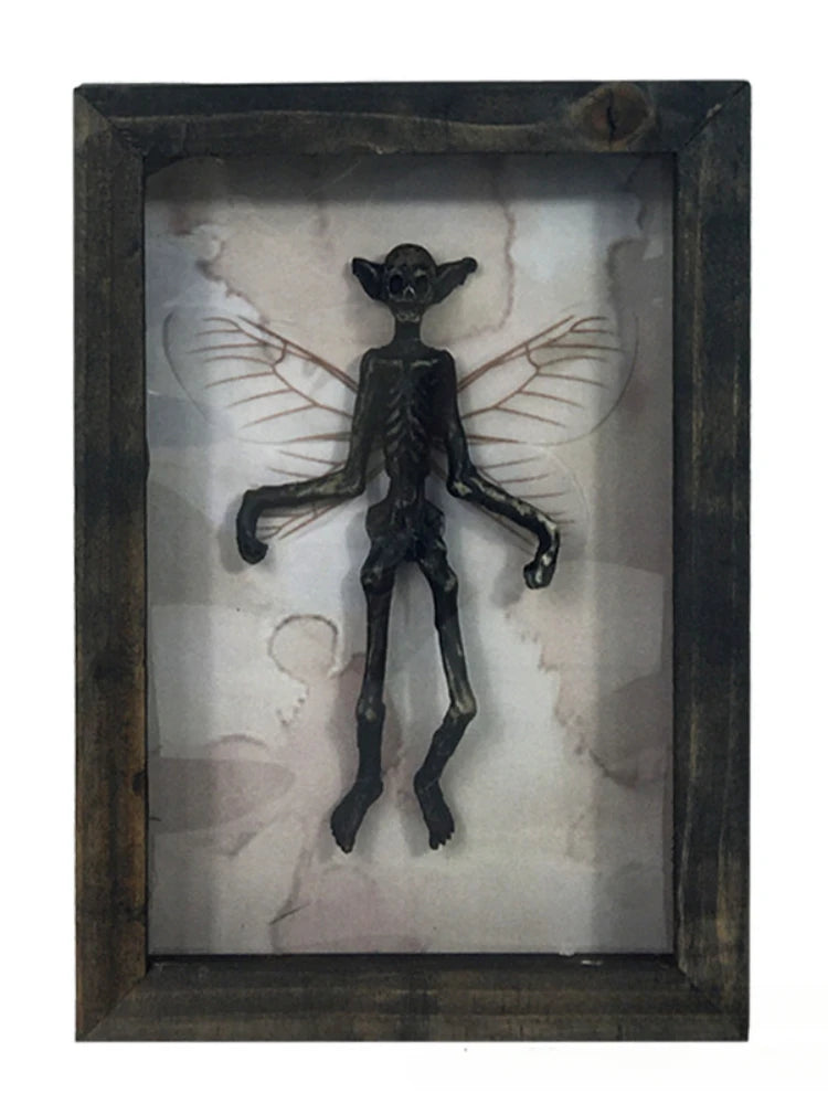 Decorative figure of a winged creature in a wooden frame