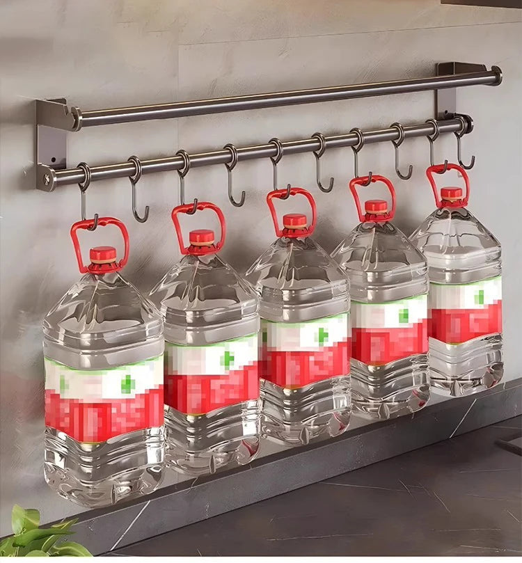 Five large water bottles with red handles hanging on a metal rack.