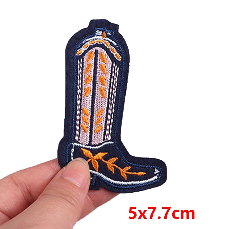 Embroidered cowboy boot patch held by a hand with dimensions 5x7.7cm on a white background.