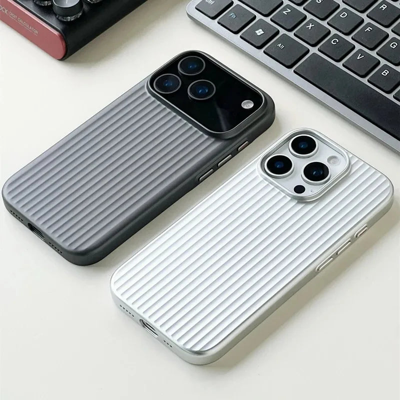 Two phone cases, one gray and one white, on a light surface with a keyboard in the background.