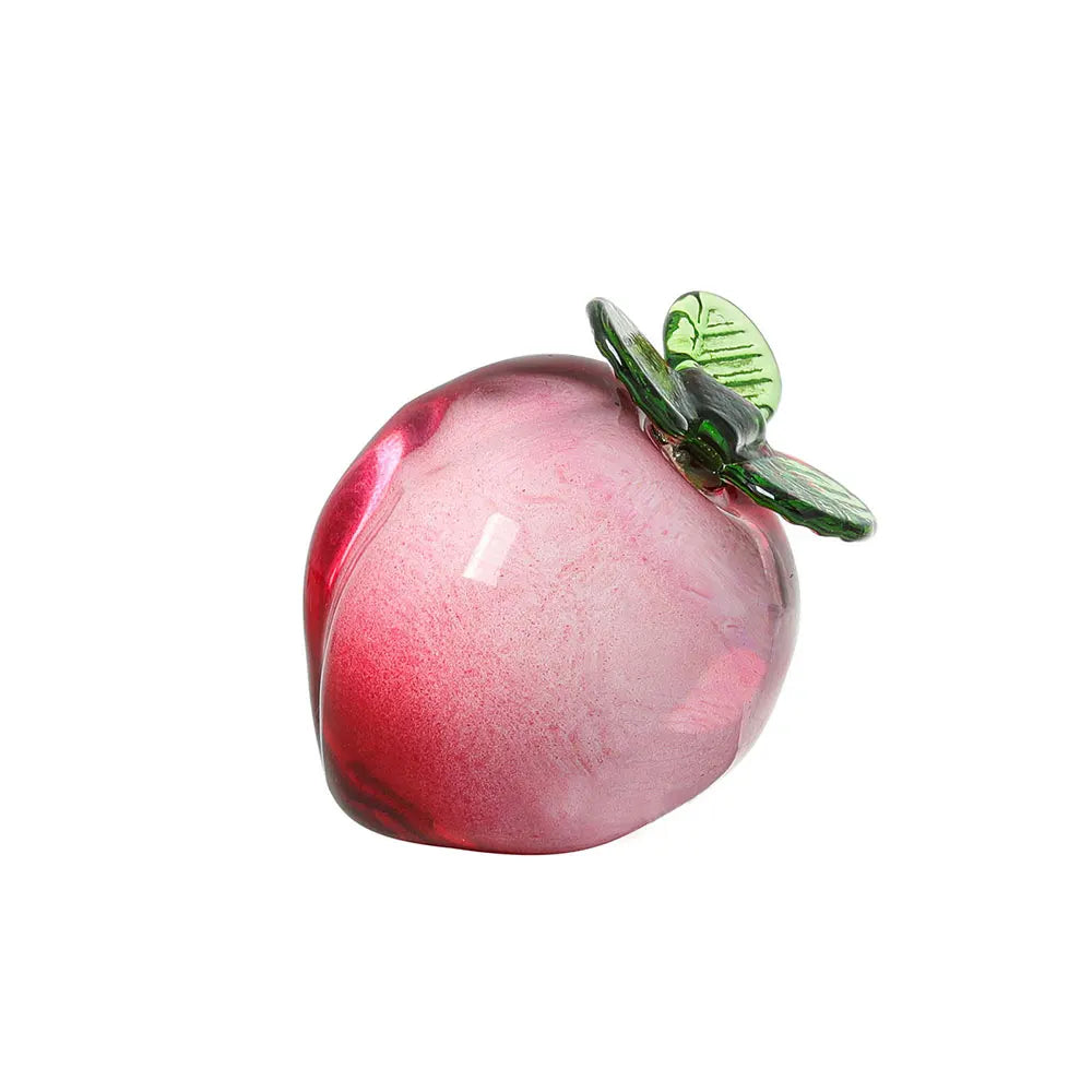 Pink glass cherry with a green leaf on a white background
