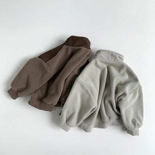 Two fleece jackets, one brown and one gray, on a white background