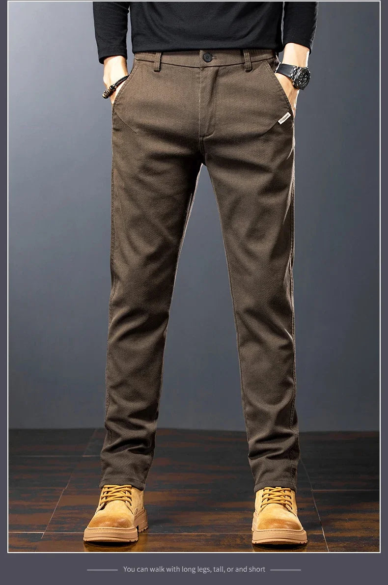 Person wearing brown pants and tan shoes on a gray background