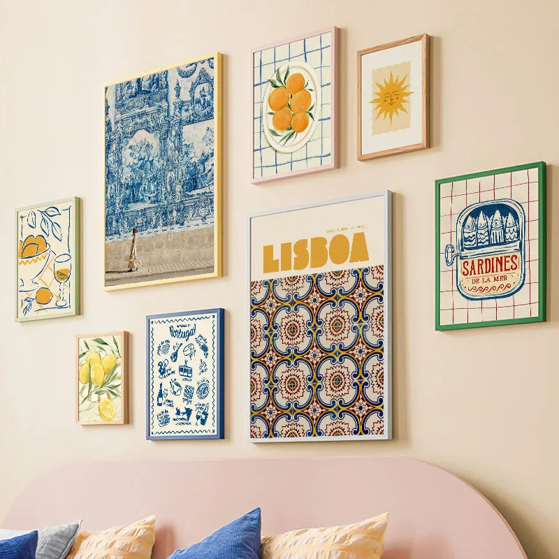 Wall with colorful framed artworks and a pink sofa with cushions.