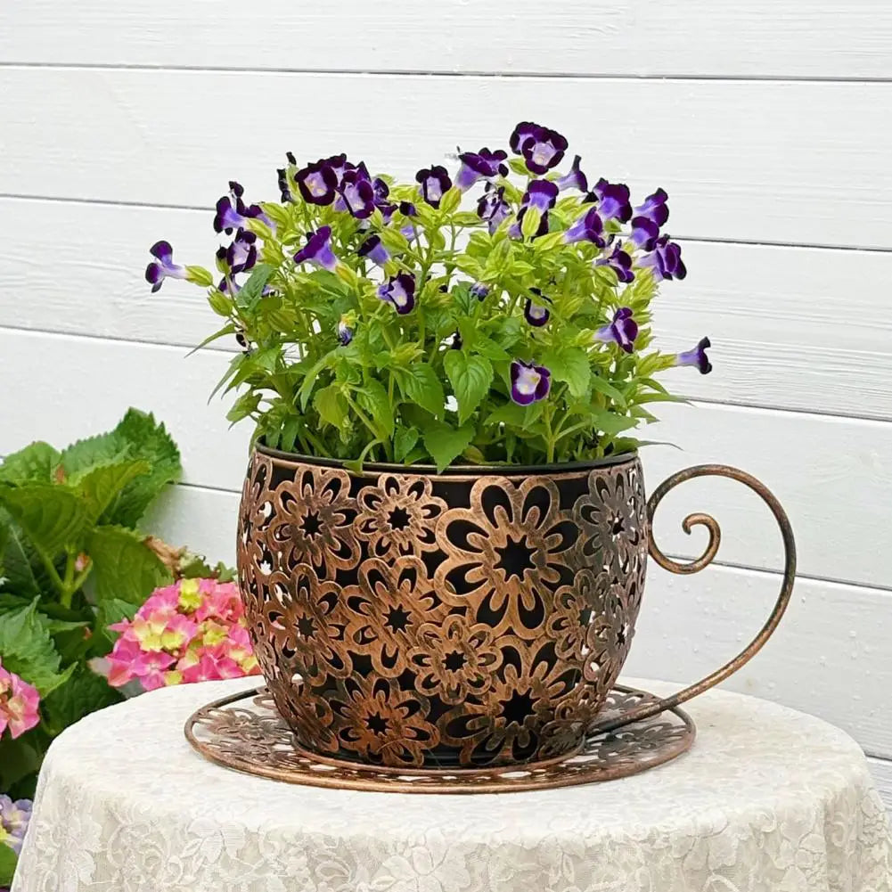 Decorative metal pot with flowers on a white surface