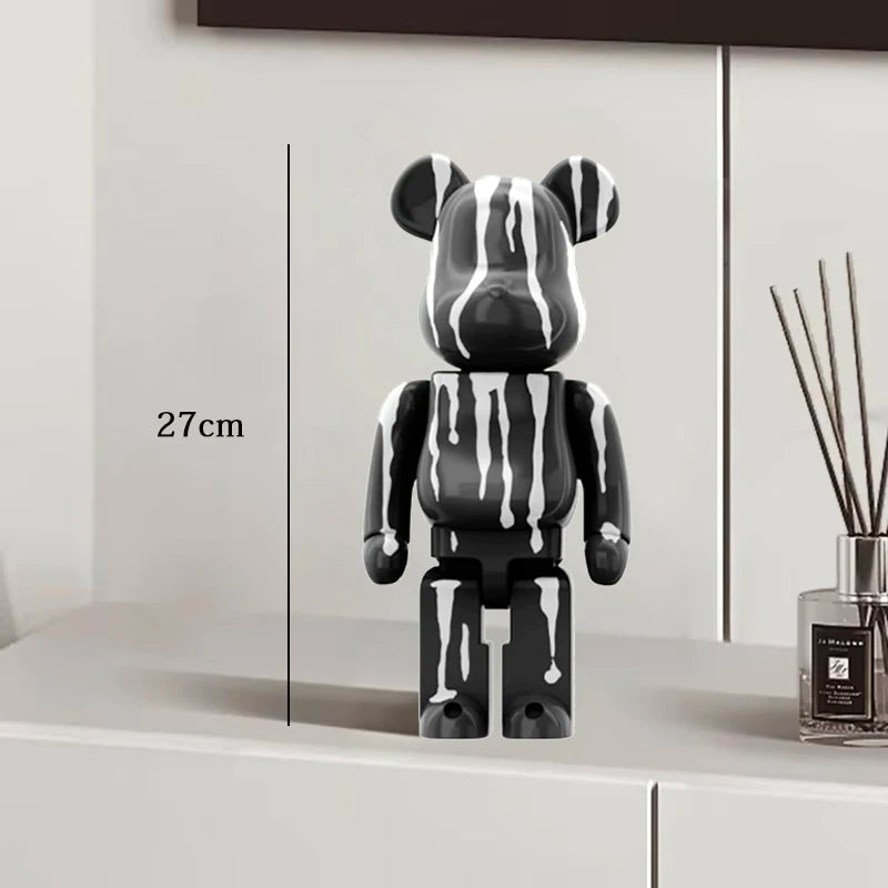 Black and white striped toy figure on a white surface with a measurement label