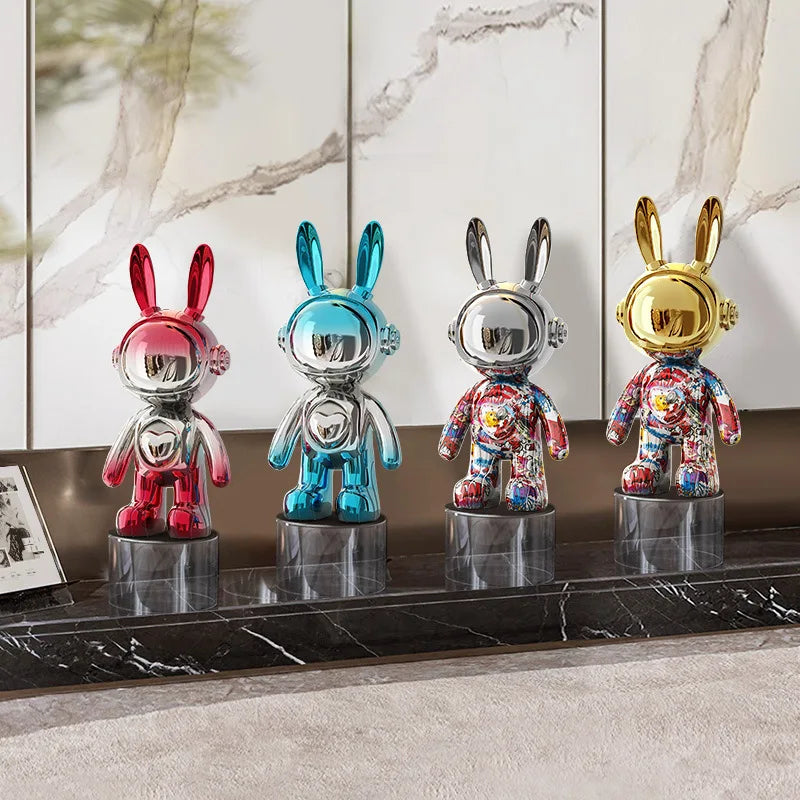 Four colorful rabbit-shaped figurines on a marble surface with a marble wall in the background.