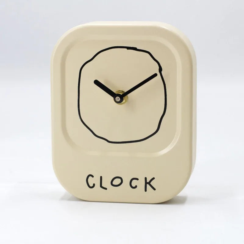 Cream tabletop decorative desk clock with minimalist modern cartoon-style dial on a clean neutral background