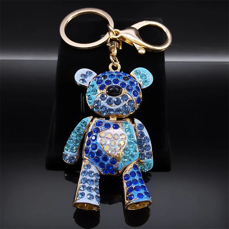 Blue teddy bear keychain with rhinestones on a black background