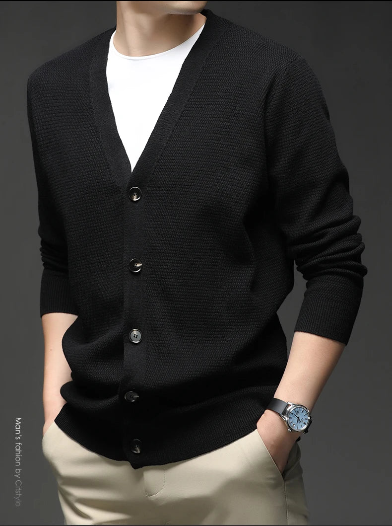 Black cardigan worn by a person on a dark background