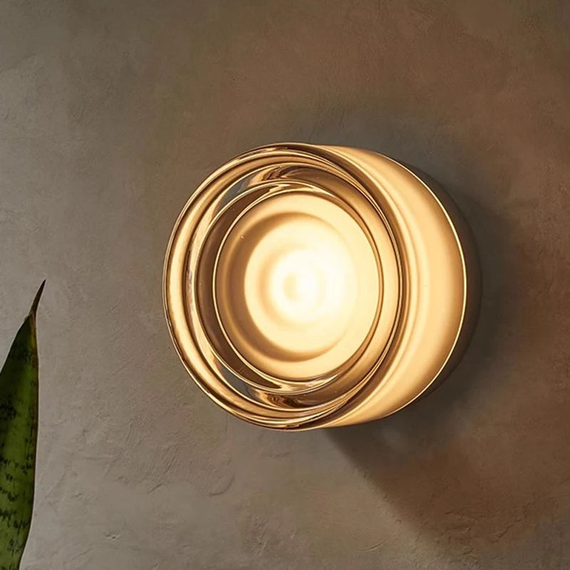 Gold wall sconce on a textured wall
