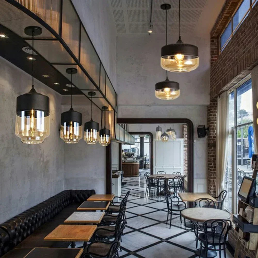 Modern restaurant interior with pendant lights, tables, and chairs.